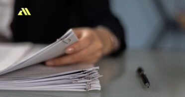 Person reviewing documents on desk